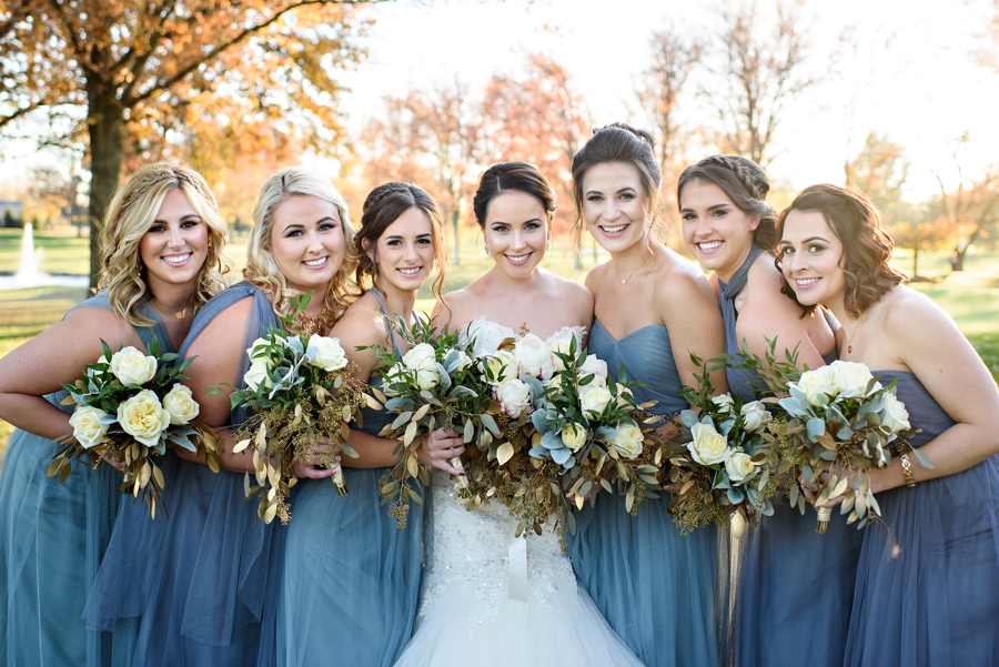 A bride and her bridesmaids pose with their colorful bouquets.